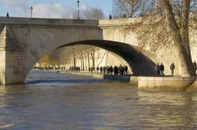 people walking on riverside of seine under bridge, france, paris