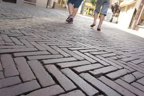 two pair of legs going away on pavement in city, netherlands