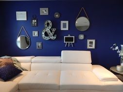 white couch at decorated blue wall in living room