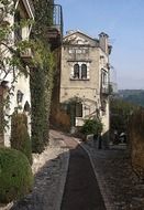 walk path at old stone houses overgrown with vines, italy