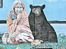 mural on wall, native indian woman and black bear sitting together