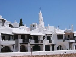 church steeple above white houses in village, spain, menorca