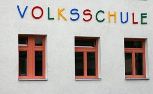 colorful lettering above windows on school facade