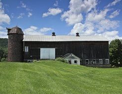 old wooden barn on meadow in countryside