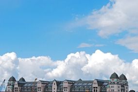 clouds in blue sky above roof of modern building, norway, oslo