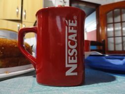 red coffee cup on table at home