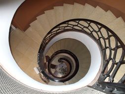 stone spiral staircase with metal railing indoor