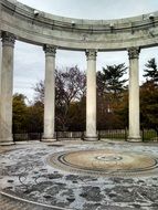 fragment of rotunda, marble columns on round mosaic floor in park