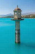 taged stone lantern on pillar in water at coastline