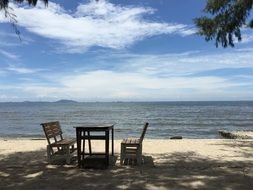 free benches and table on beach at sea