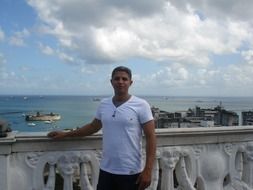 mature asian man at balustrade in view of harbor