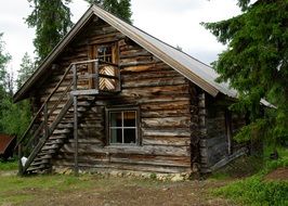 log house with external staircase among trees. finland