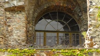 arched window in aged stone wall