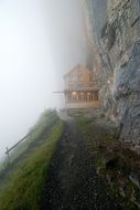 wooden hut on rock in mist
