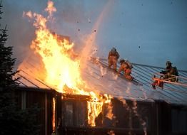 firefighters at work on roof of burning building, usa, alasla