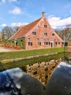 landscape of old traditional brick building at water, netherlands