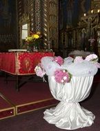 white vase, decorated with flowers, in church