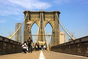 young men, photographer and model on brooklyn bridge, usa, nyc