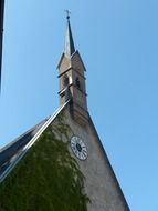 roof of old church with clock and spire at sky