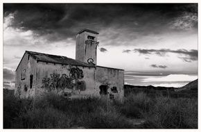 abandoned building in rural landscape, black and white