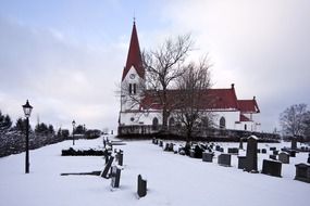 old cemetery at church in snowy winter, sweden