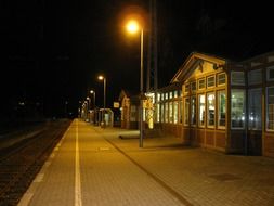 row of lanterns on train station platform at night, germany