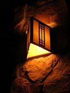 triangular lantern on stone wall