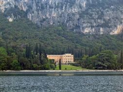 palace on coastline at forested mountain, italy, garda