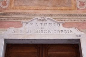 vintage stone carved lettering above entrance door of hospital