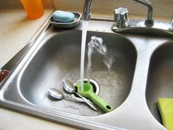 spoons inside stainless steel sink in kitchen