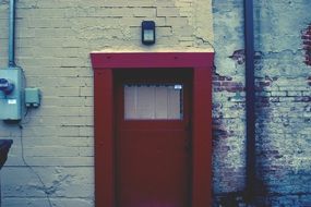 burgundy door on a brick wall