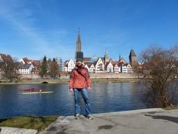 young man on riverside in view of ulm cathedral in germany in munich