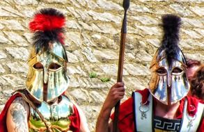 two men in face helmets and ancient military costumes