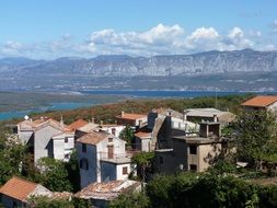 old village at sea in view of mountains, croatia