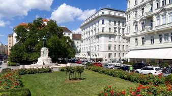 square with flower beds and monument in city at summer, vienna, austria