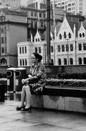 mature woman resting on bench on street in city, china, shanghai