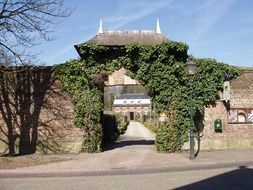 stone wall with gateway in front of castle, netherlands, amstenrade