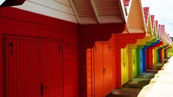 colorful wooden dressing rooms on beach in row