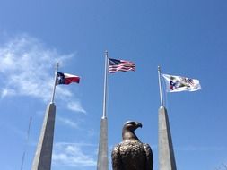 eagle sculpture and american flags at sky, usa, texas war memorial