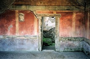 doorway in red wall of ancient ruins, italy, pompei