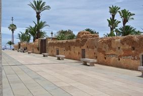 benches on pavement along old city wall, morocco, rabat