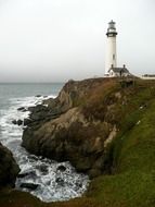 Pigeon Point Lighthouse on rocky coast at clouds, usa, california