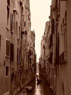 people in boat on narrow canal, italy, venice