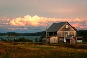 weathered wooden buildings on lake coast at sunset, canada, british columbia, lac la hache