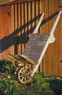 old wooden wheelbarrow at wall outdoor