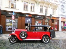 red vintage car on pavement in old town, czech, prague
