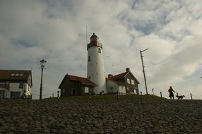 silhouette of a woman with a dog near the lighthouse