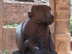 nandi, bull statue at red wall of ancient temple, india, pattadakal