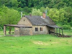 old village building with shed at green forest