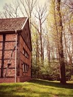 timber framed red brick building among trees at spring